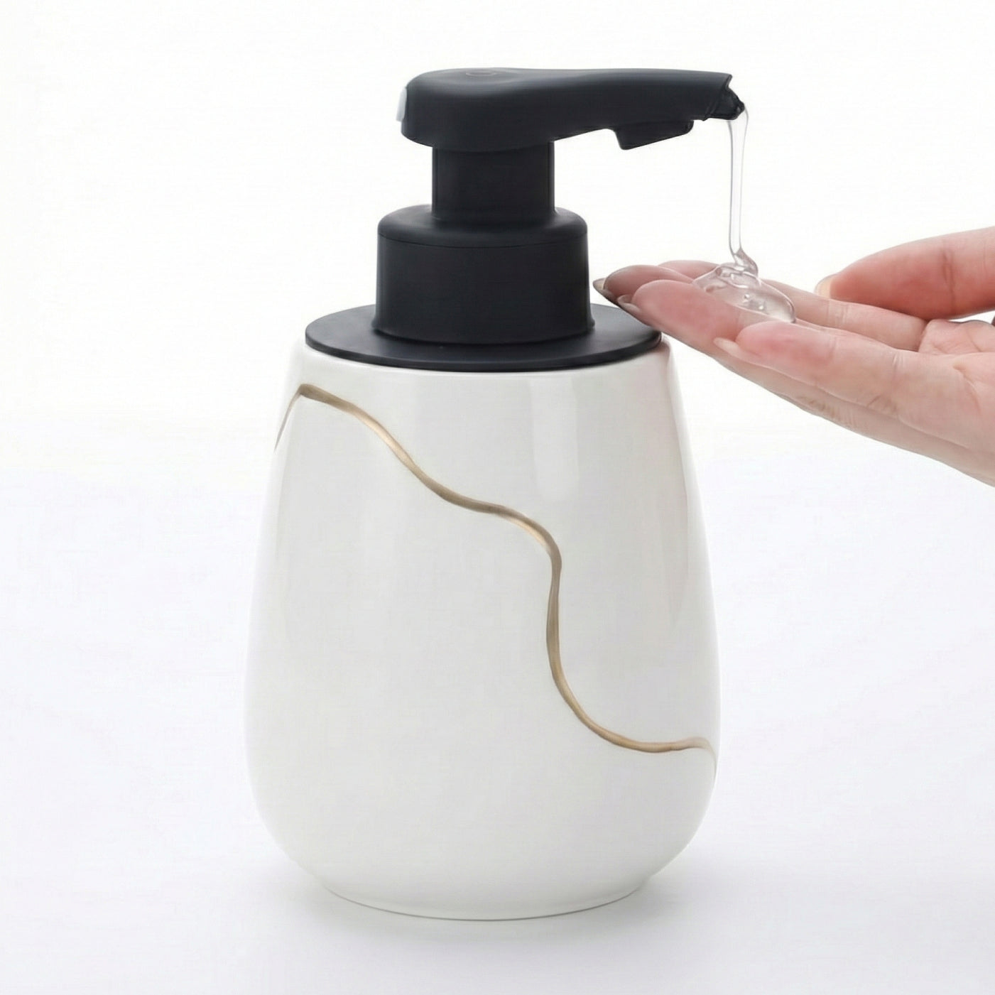 BosilunLife Nordic Garden 17 oz automatic liquid soap dispenser made of recycled eco-clay, featuring a white base with a gold wave design, dispensing clear gel soap into a hand.