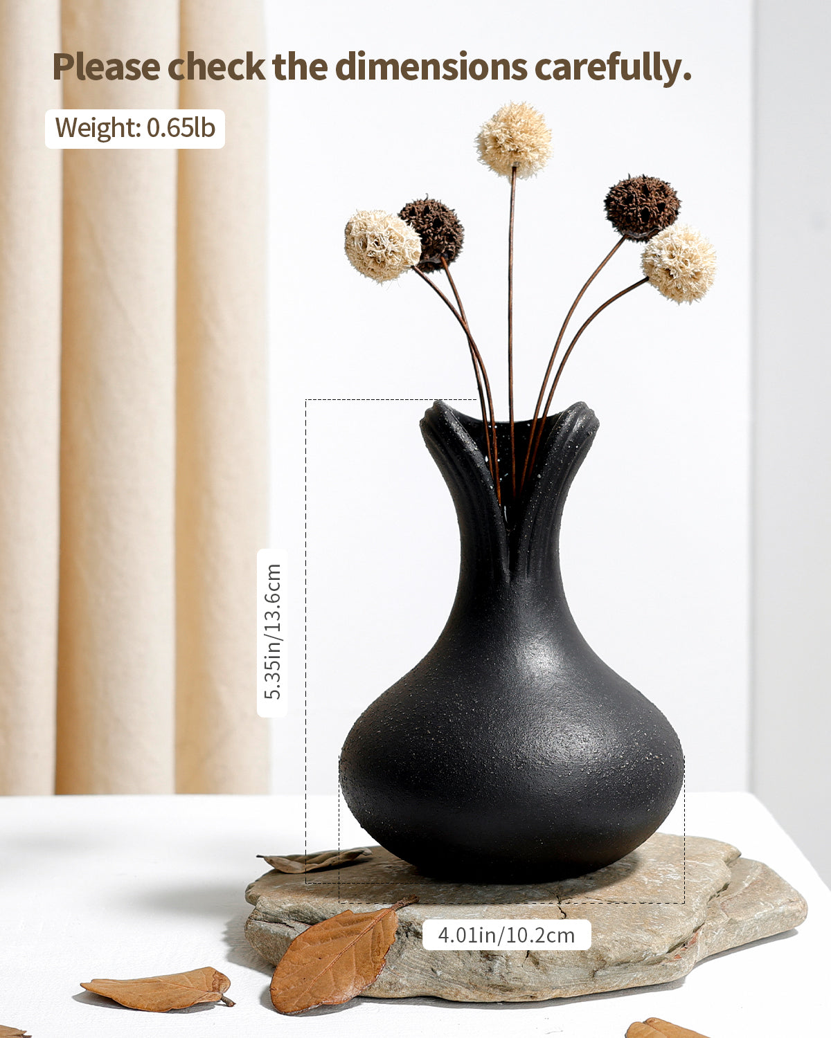 Black vase with dried flowers on a white background
