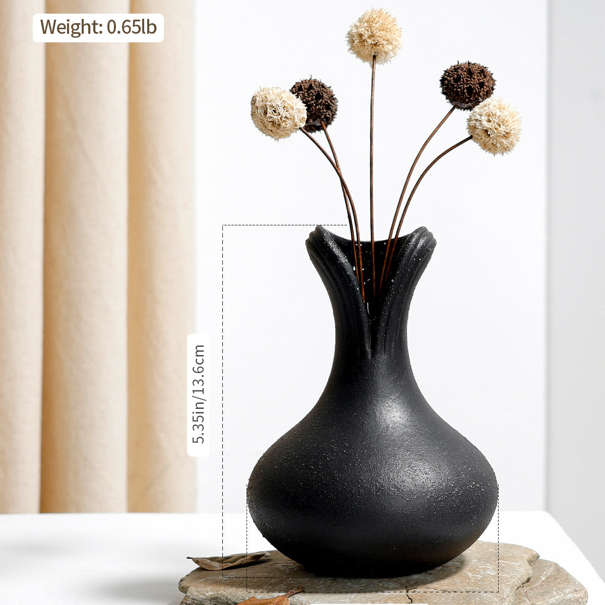 Technical dimension chart for the BosilunLife sculptural black flower vase in recycled eco-clay. The textured matte black vase is styled with dried botanicals on a stone slab. Overlaid text specifies a height of 5.35 inches (13.6 cm) and a weight of 0.65 lbs, highlighting its compact, stable design for modern tabletops.