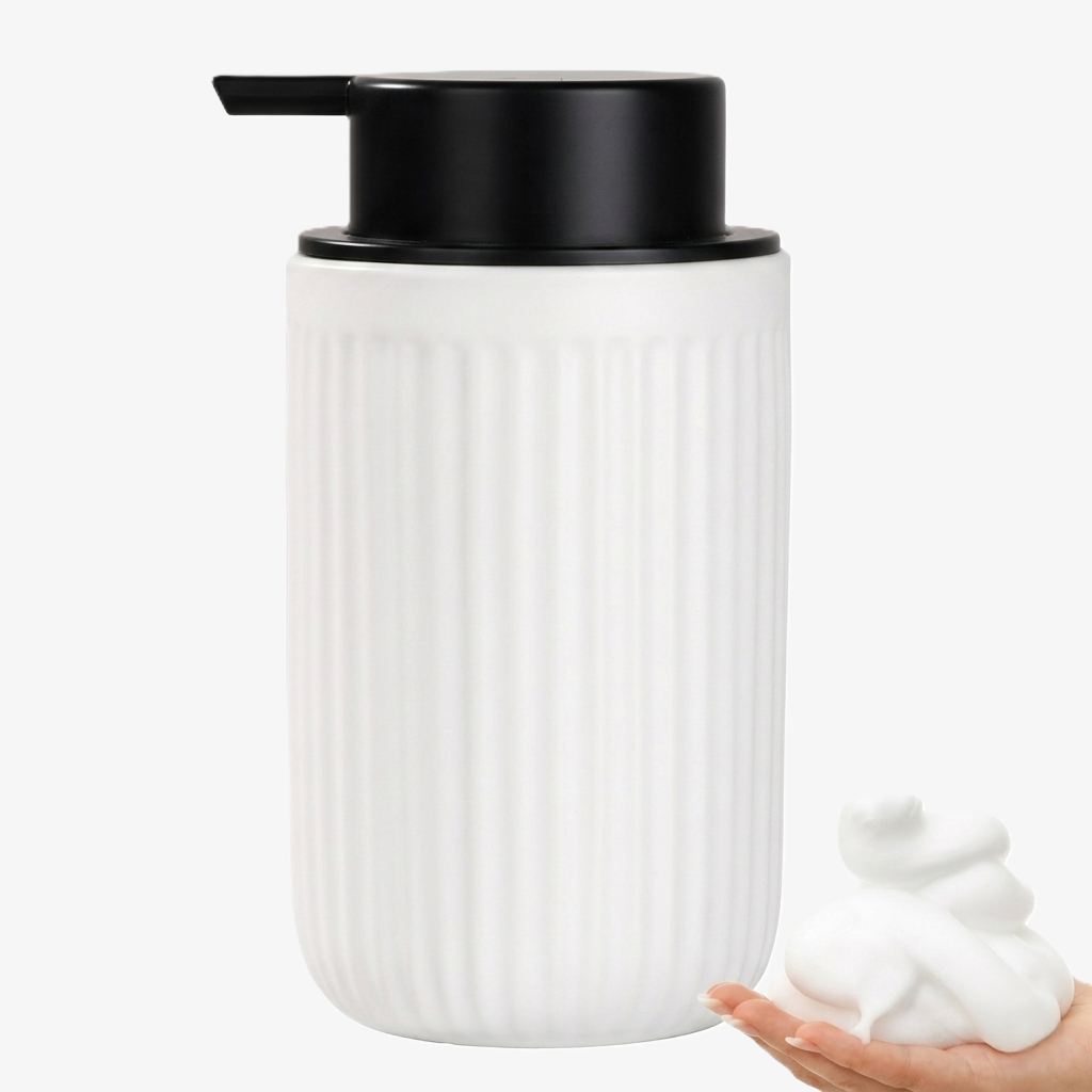 BosilunLife Pockmark 12 oz foaming soap dispenser in crisp white recycled eco-clay. Features a vertically ribbed volcanic stone texture with a contrasting matte black pump and an inset showing thick white foam in a hand.