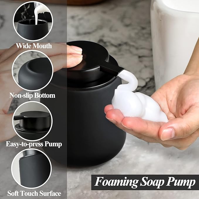 A human-centric lifestyle photograph showing a hand operating the BosilunLife 12 oz White Rubber Paint Foaming Soap Dispenser. The dispenser sits on a round bamboo tray, actively dispensing a rich, velvety white foam into the palm. Set against a serene, neutral washroom background with greenery, the image visualises water-saving efficiency and high-end Scandinavian design.