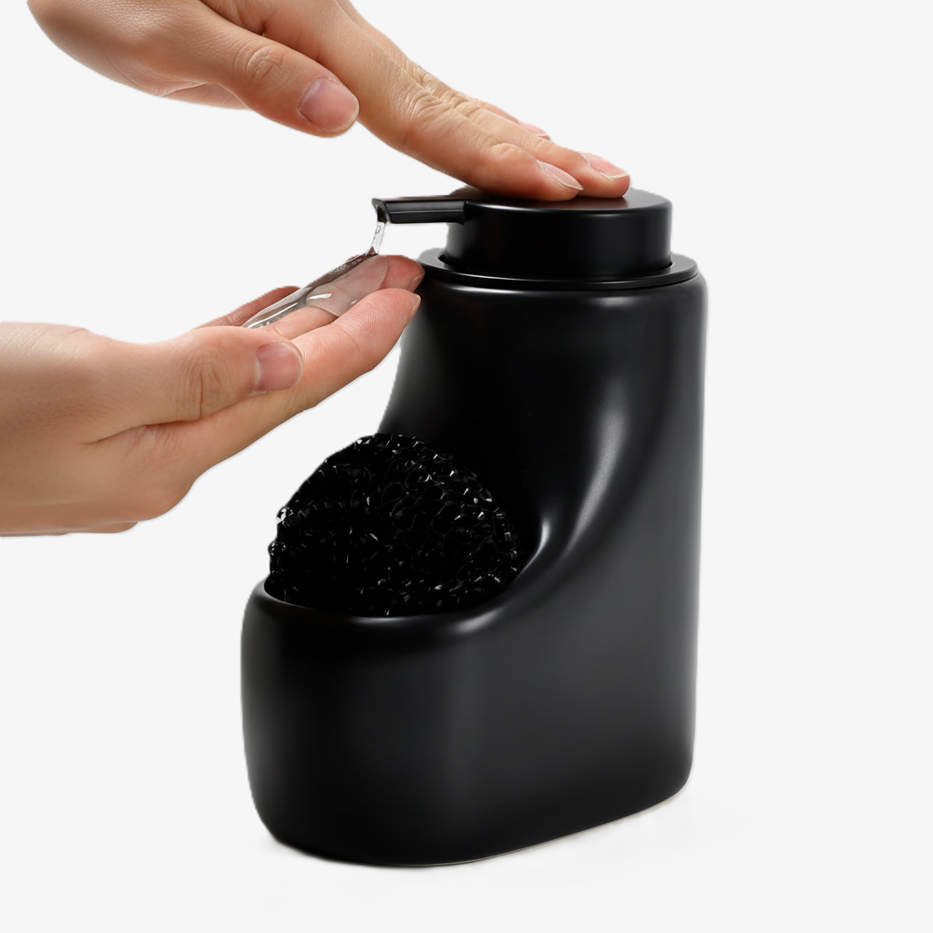 BosilunLife Scandi Grove 15.55 oz liquid soap dispenser in matte black recycled eco-clay with integrated sponge holder. A person's hands are shown dispensing clear dish soap from the wide matte black pump, highlighting the space-saving sink caddy design for modern kitchens.