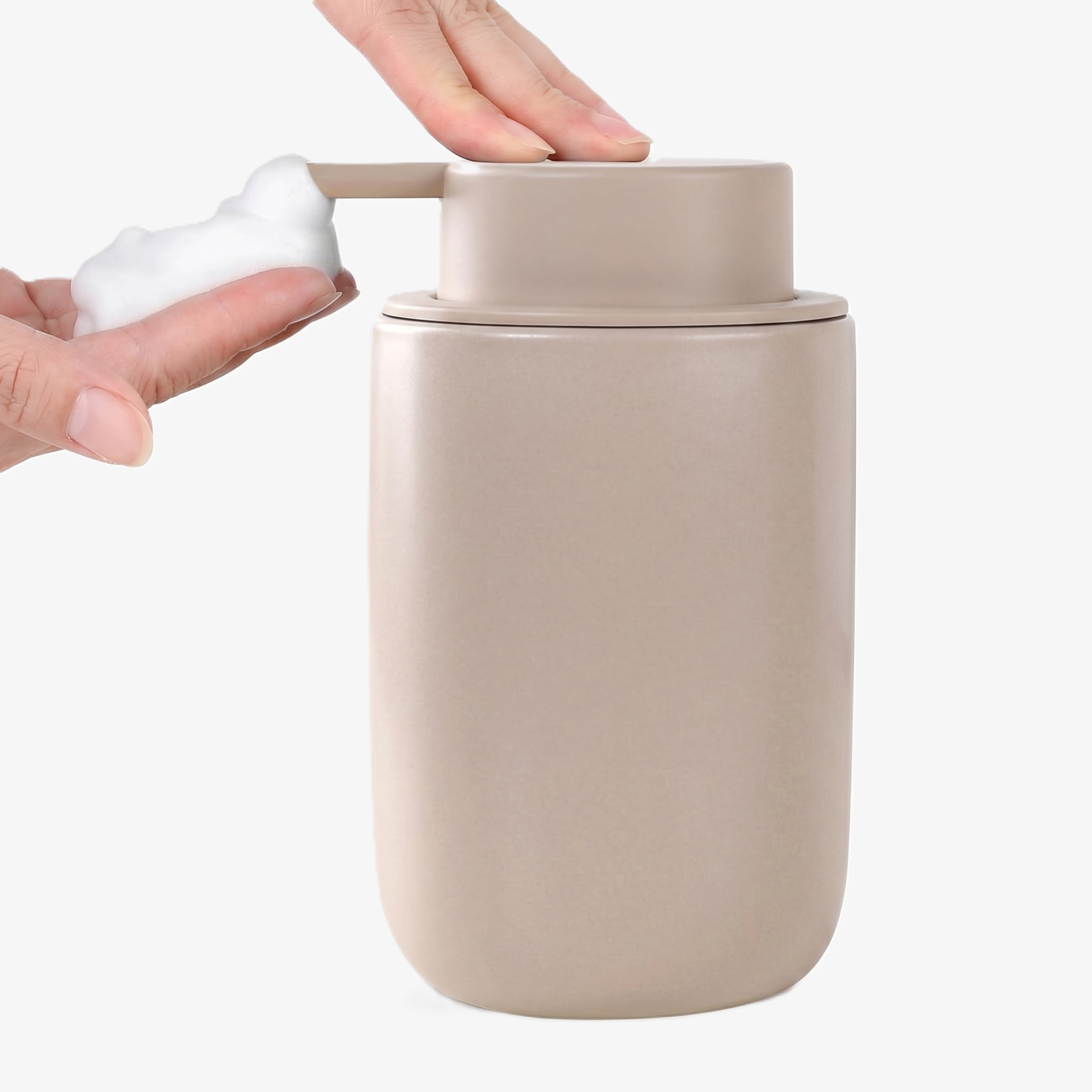 Close-up action shot of the BosilunLife 12 oz (350ml) slim foaming soap dispenser in a monochromatic matte khaki finish. A hand is shown pressing the matching wide-head pump to receive a mound of rich, velvety white foam from the slender organic vessel. Crafted from GRS-certified recycled ceramic eco-clay, this space-saving organiser reflects Scandinavian functionality and a commitment to a sustainable circular economy, perfect for narrow washroom vanities and neutral-toned interiors.