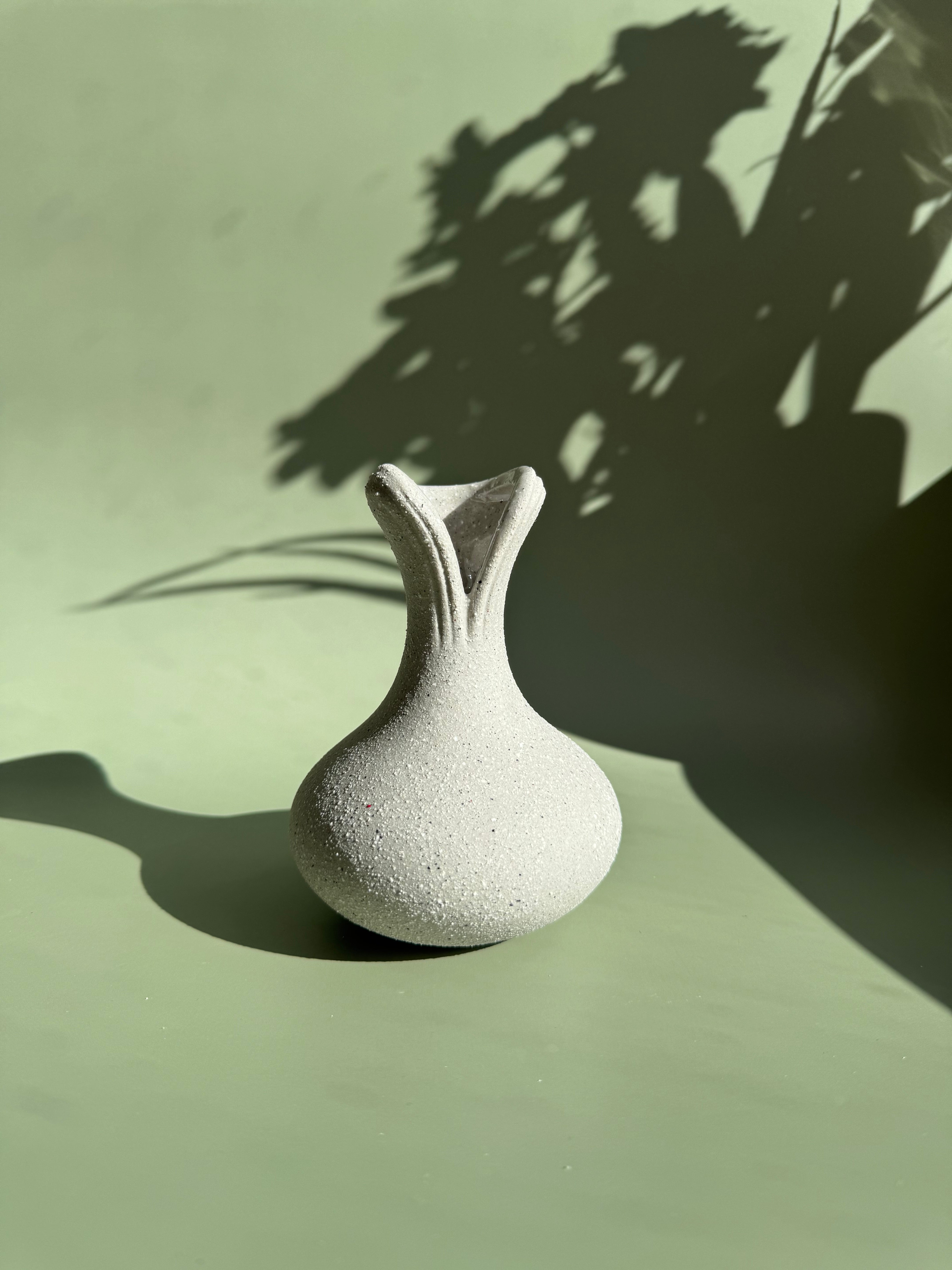 BosilunLife recycled eco-clay ceramic vase styled empty against a light green background with dramatic natural plant shadows.