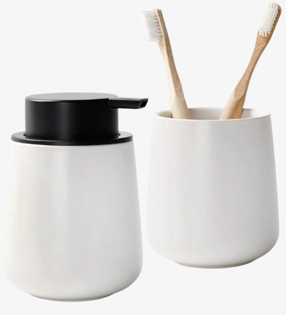 White soap dispenser with black cap and white cup with bamboo toothbrushes on a white background