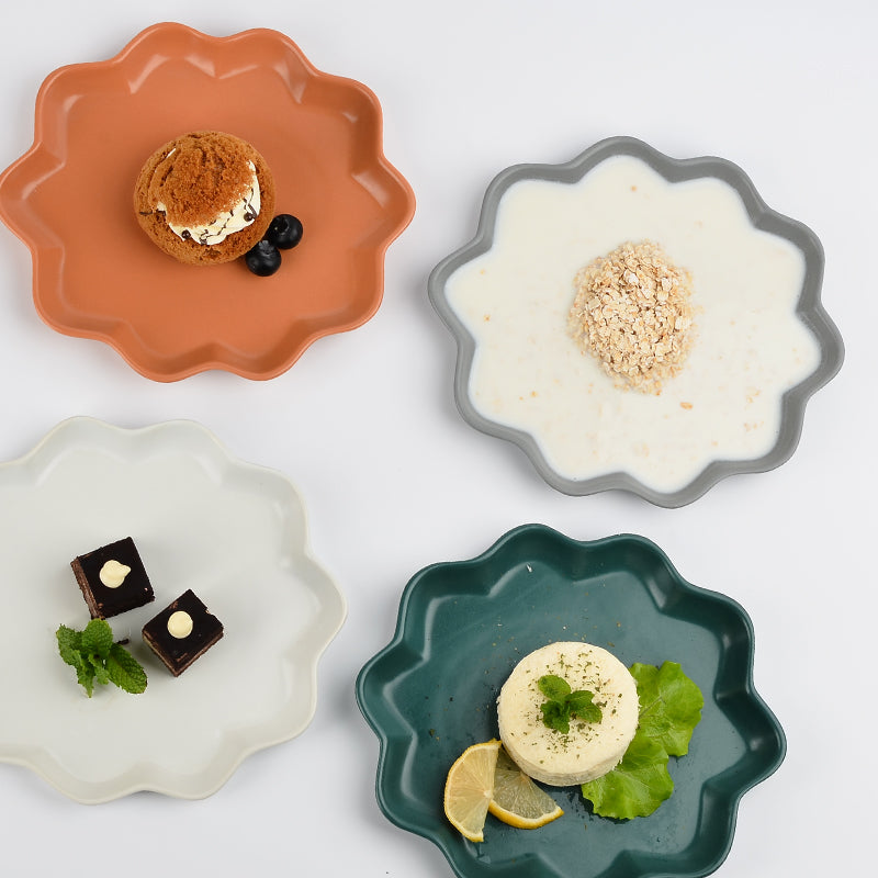 Four deep plates of different colors with food