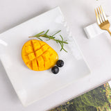 White square ceramic dinner plate with mango and blueberries