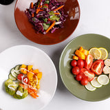 3 deep plates of different colors with salads