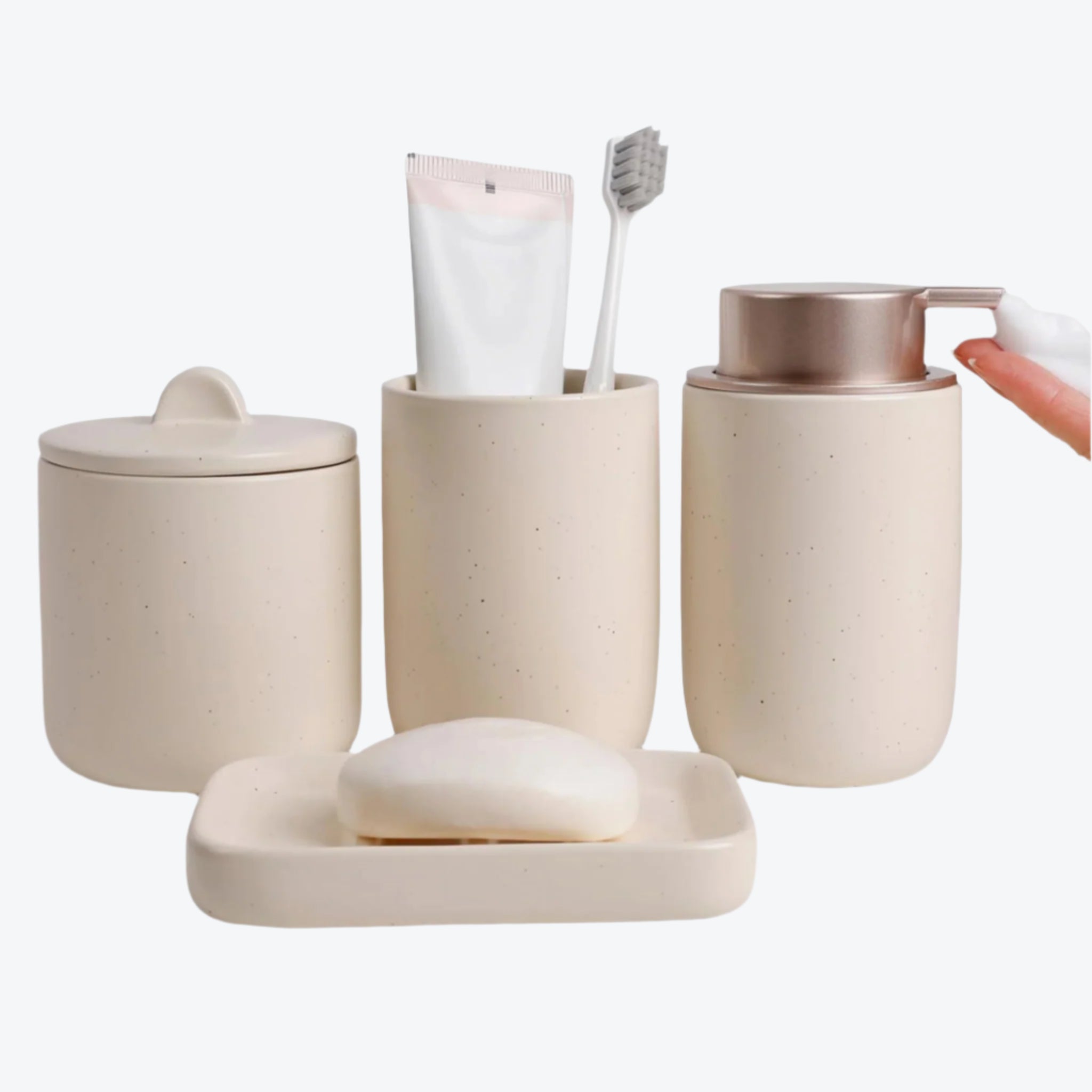 Beige bathroom accessory set with containers, a soap dish, and a hand holding a soap dispenser.