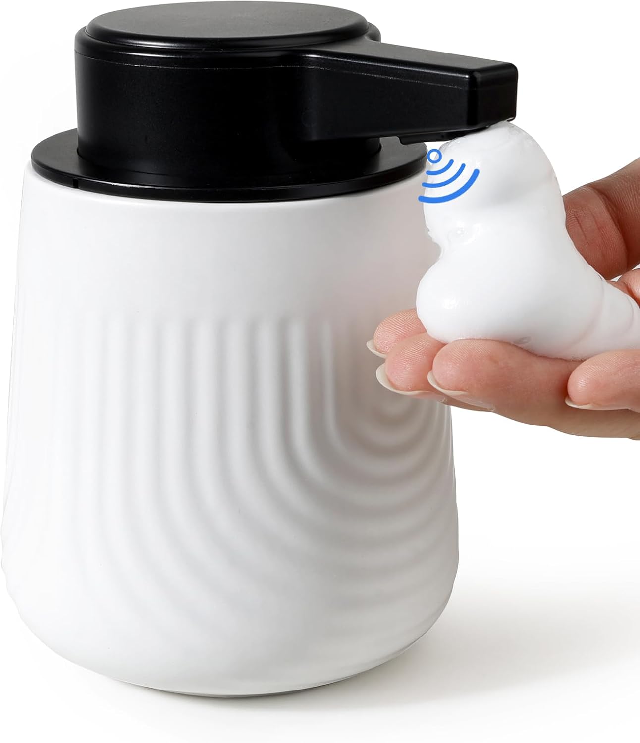 White ceramic mug with black lid and a small white device being held next to it.