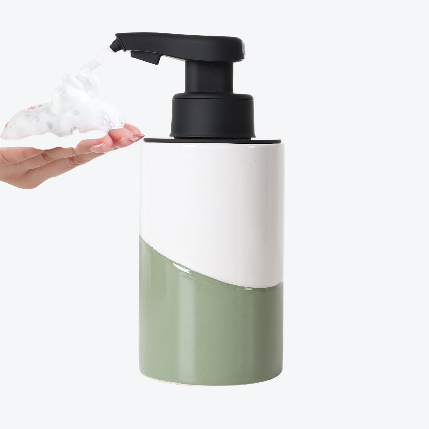 Green and white foam soap dispenser with pump being used on a white background