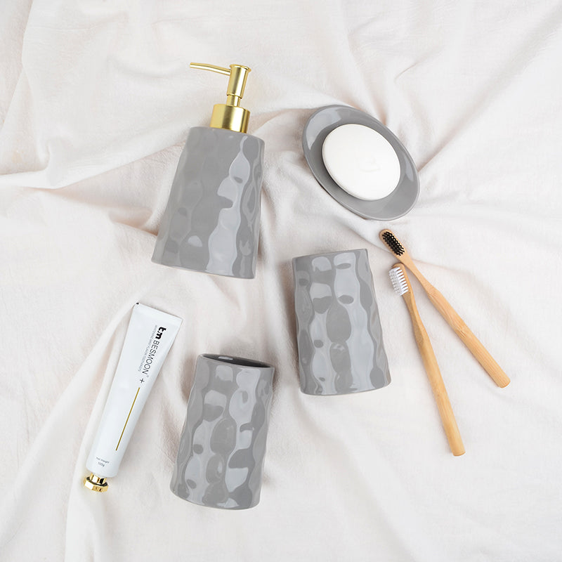 Overhead lifestyle view of the grey BosilunLife Bring Nature Inside recycled eco-clay 4-piece liquid bathroom set styled on a white fabric background.