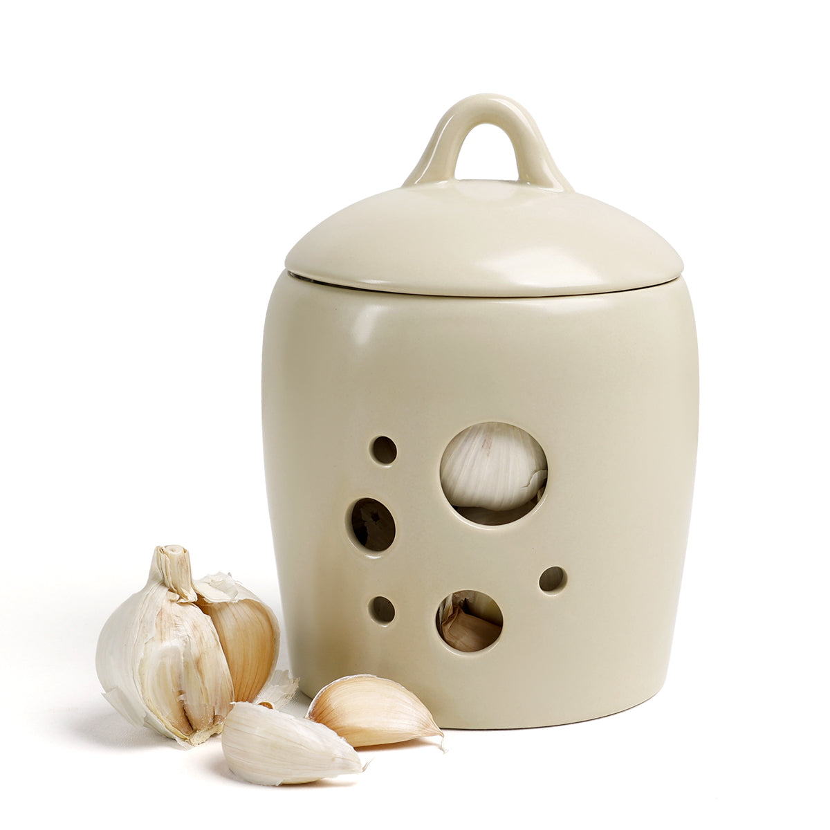 Ceramic garlic keeper with a handle and holes for air circulation, accompanied by garlic bulbs on a white background.