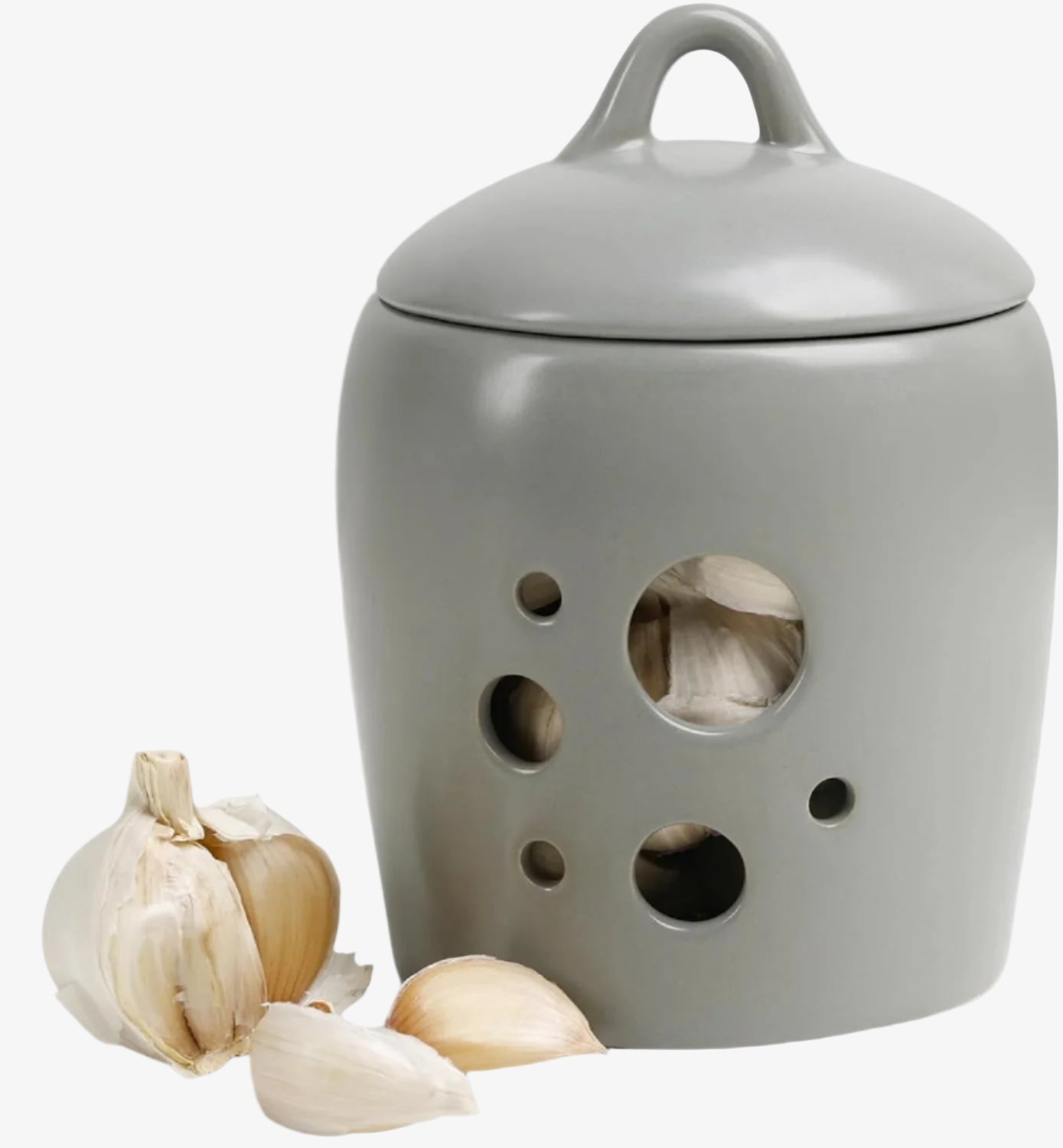 Gray ceramic garlic keeper with holes and garlic cloves on a white background