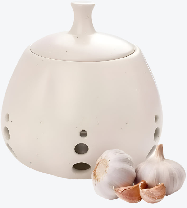 White ceramic container with garlic cloves on a white background