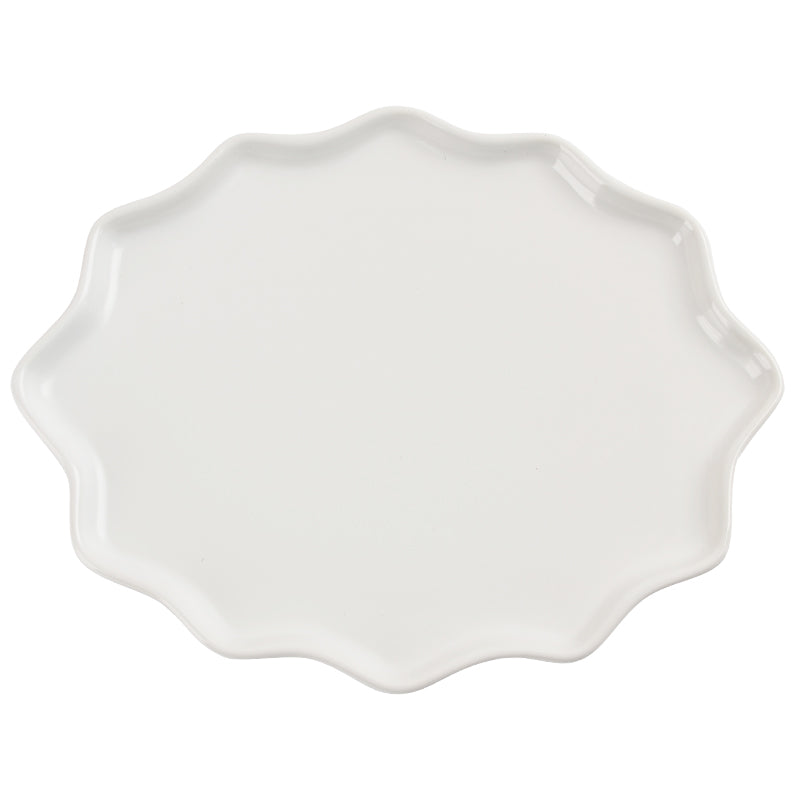 An irregularly shaped white dinner plate